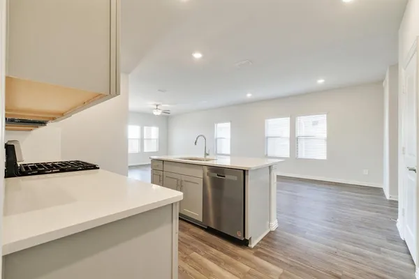a large kitchen with a sink a window and stainless steel appliances