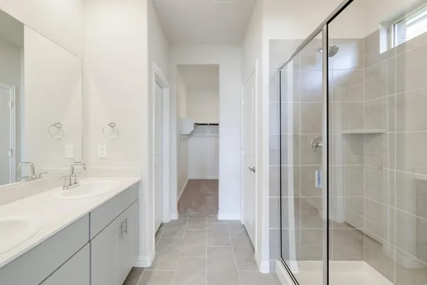 a bathroom with a double vanity sink a mirror and a shower