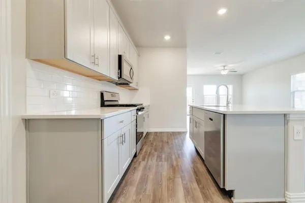a kitchen with cabinets and wooden floor