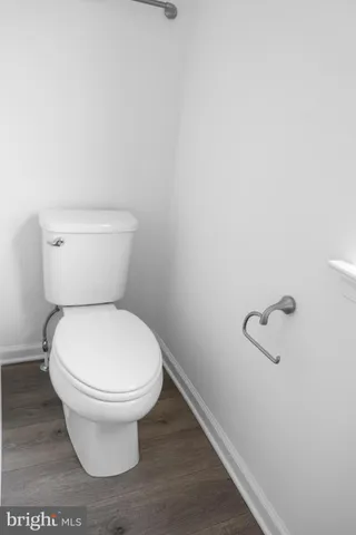 a white toilet sitting next to a white wall
