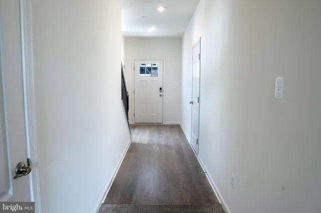 a view of a hallway with wooden floor