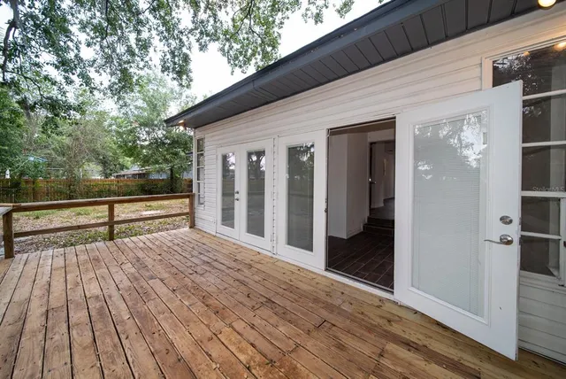 a view of backyard with wooden floor and fence