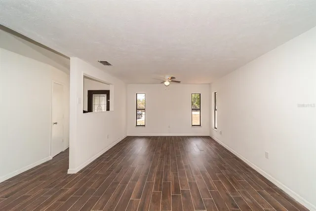 a view of a room with wooden floor and white walls