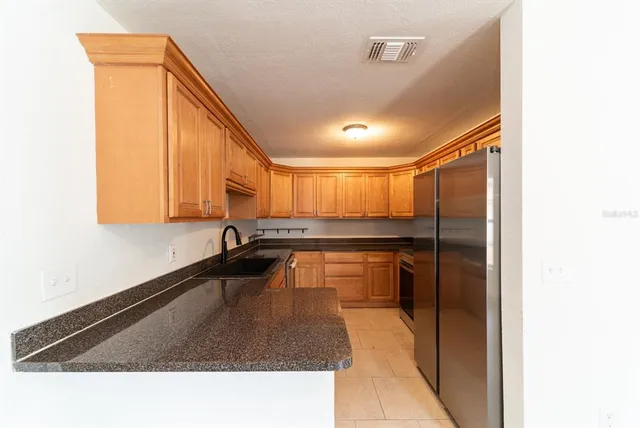 a kitchen with stainless steel appliances granite countertop white cabinets and a stove top oven