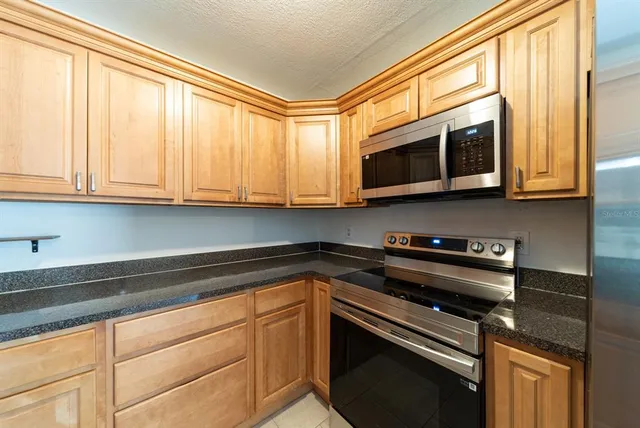 a kitchen with granite countertop a sink and cabinets