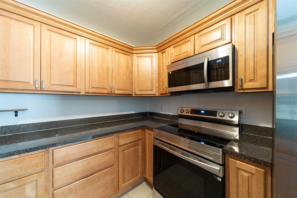 6345 Hatcher Road Lakeland, FL 33811 - Photo 39 of 41 a kitchen with stainless steel appliances granite countertop white cabinets and a stove top oven