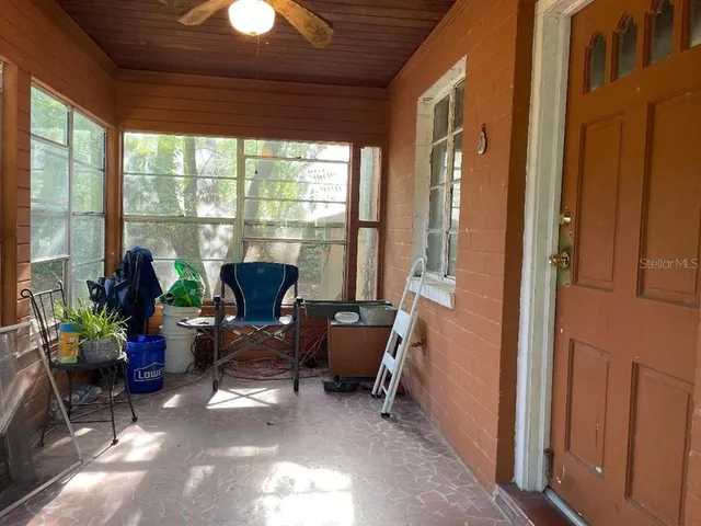 a front view of a house with a yard and a large tree