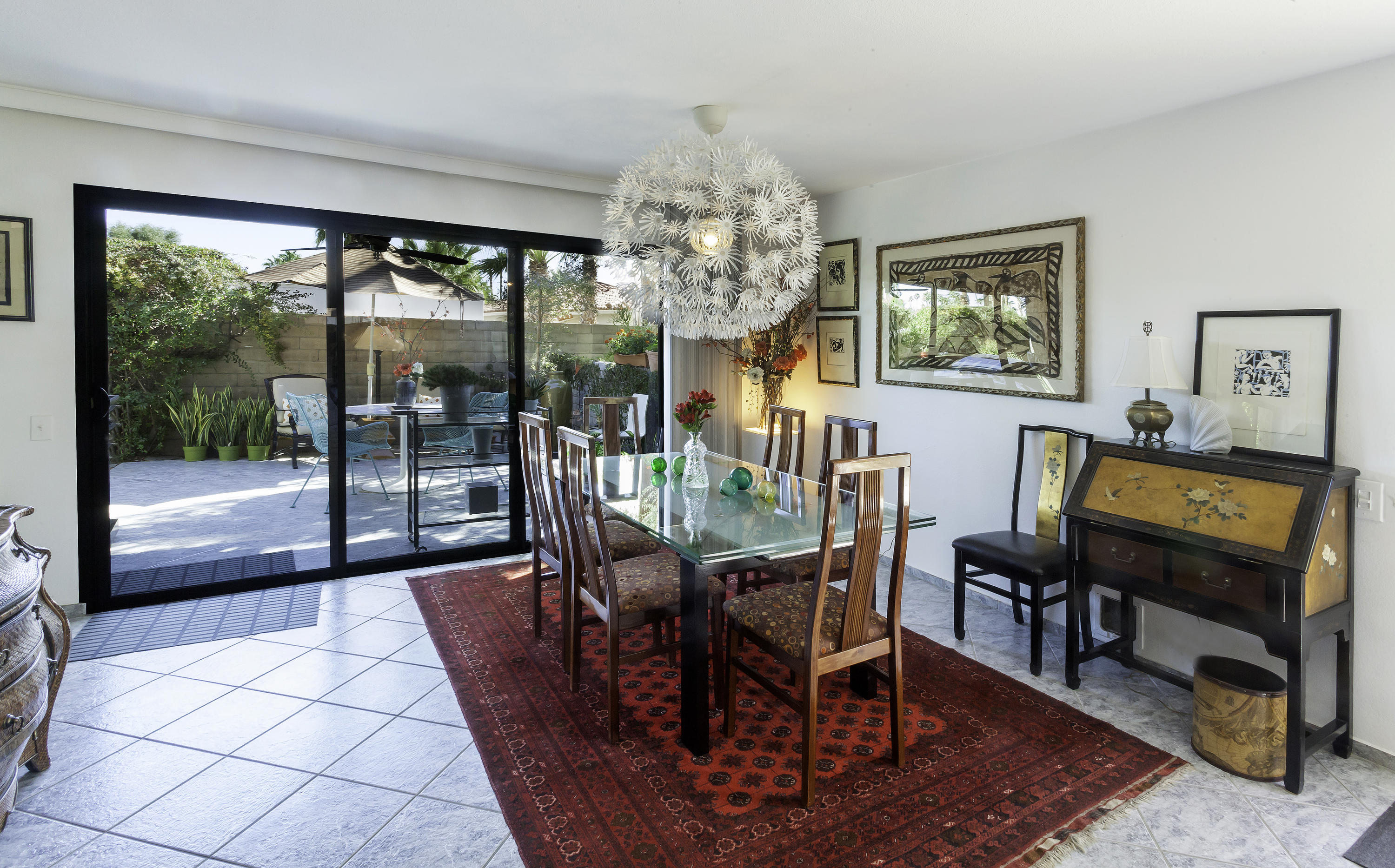 1111 Ramon Road, Unit 88 Palm Springs, CA 92264 - Photo 11 of 24 a view of a dining room with furniture a chandelier and wooden floor