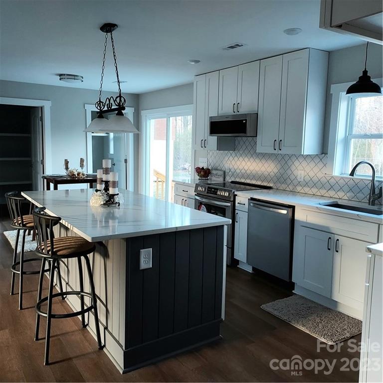5601 Medlin Road Monroe, NC 28112 - Photo 12 of 29 a kitchen with stainless steel appliances granite countertop a stove a sink dishwasher and cabinets with wooden floor
