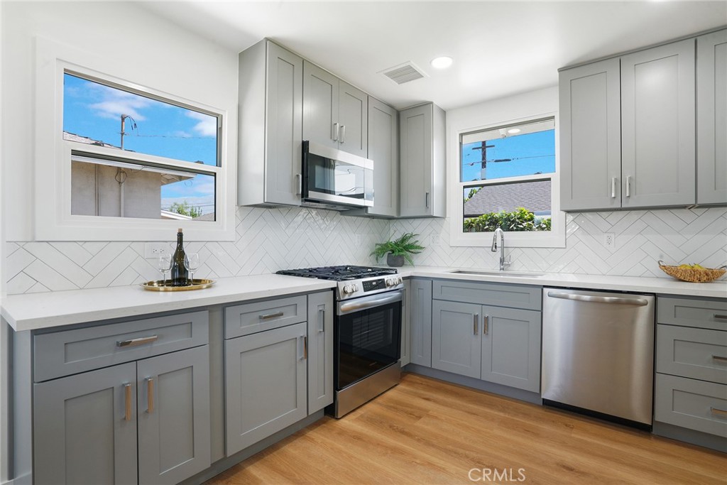 5626 Lenore Avenue Arcadia, CA 91006 - Photo 8 of 23 a kitchen with white cabinets a sink and appliances