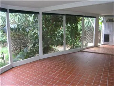 an empty room with large windows and view of trees