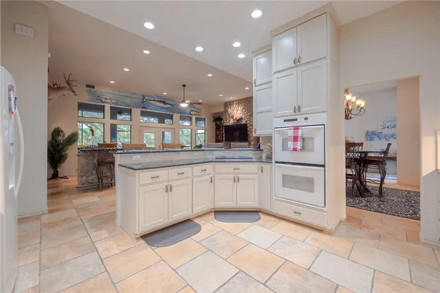 a kitchen with granite countertop white cabinets and white appliances