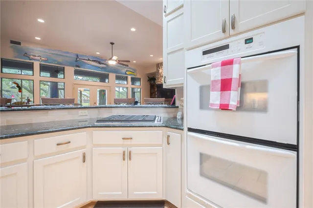 a kitchen with granite countertop cabinets and white appliances