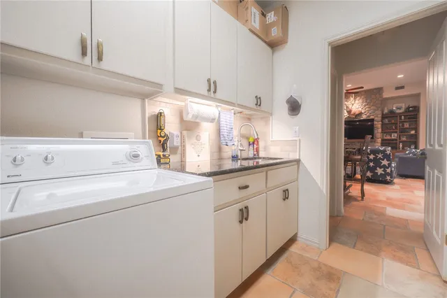 a bedroom with a bed a large window and chandelier