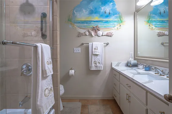 a bathroom with a granite countertop sink a toilet and shower