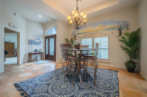 a view of a dining room with furniture and a chandelier