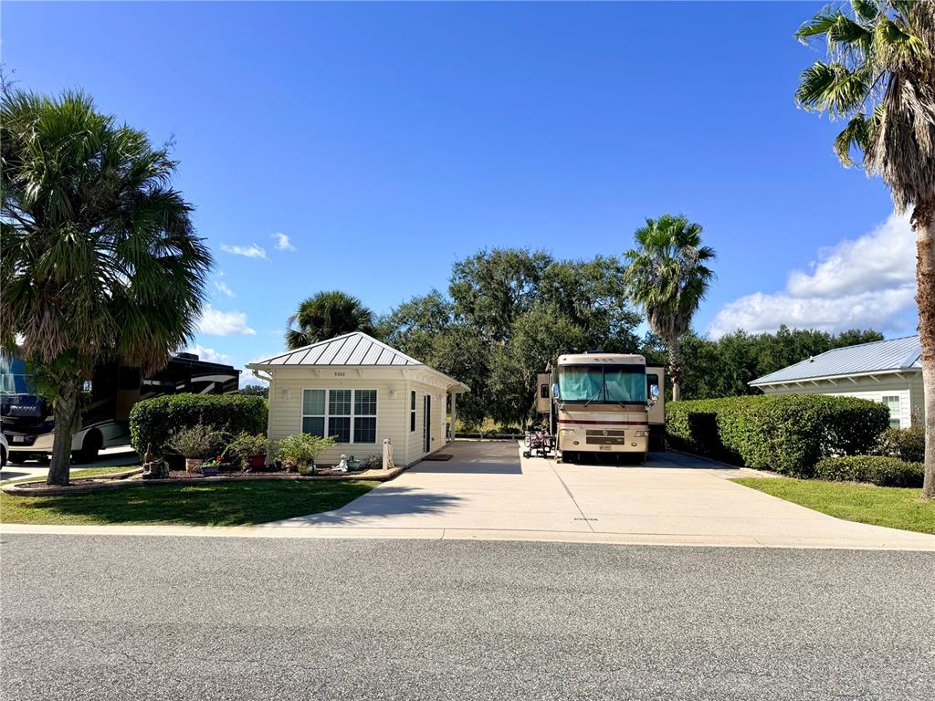 a front view of a house with a yard and potted plants