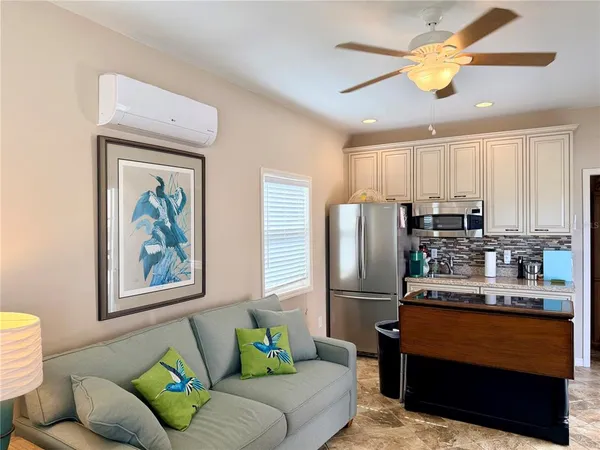 a living room with stainless steel appliances furniture and a window