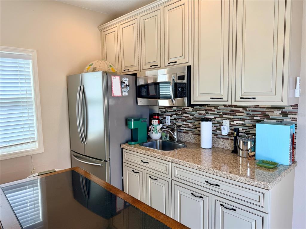9588 Southeast 47th Way Webster, FL 33597 - Photo 20 of 43 a kitchen with stainless steel appliances a refrigerator sink and cabinets