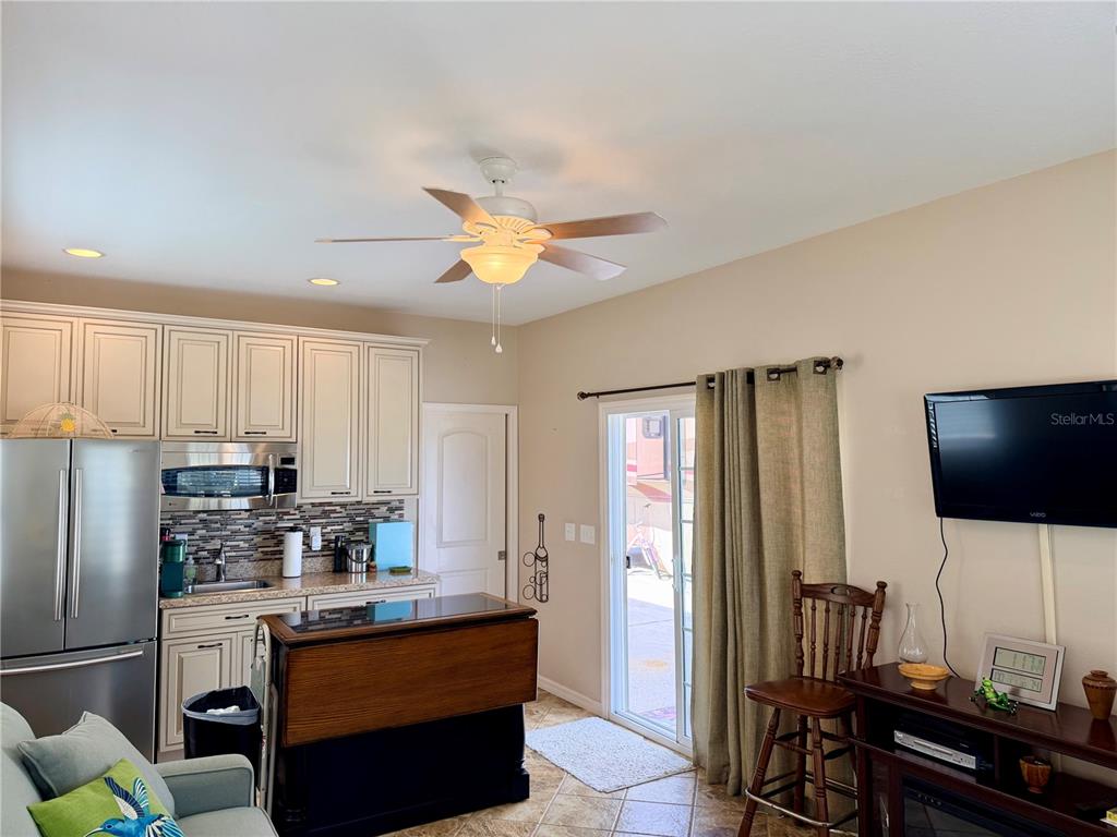9588 Southeast 47th Way Webster, FL 33597 - Photo 21 of 43 a kitchen with stainless steel appliances granite countertop a refrigerator a stove a sink a dining table and chairs with wooden floor