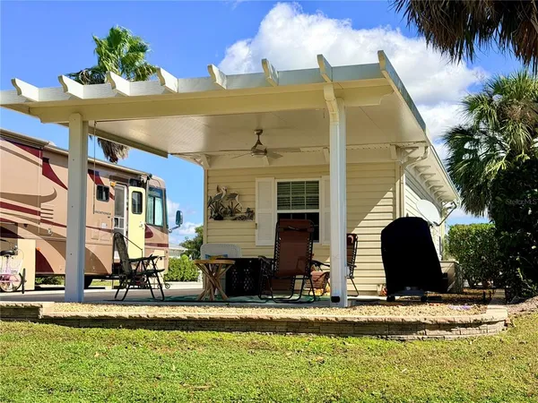 front view of house with a yard and palm trees