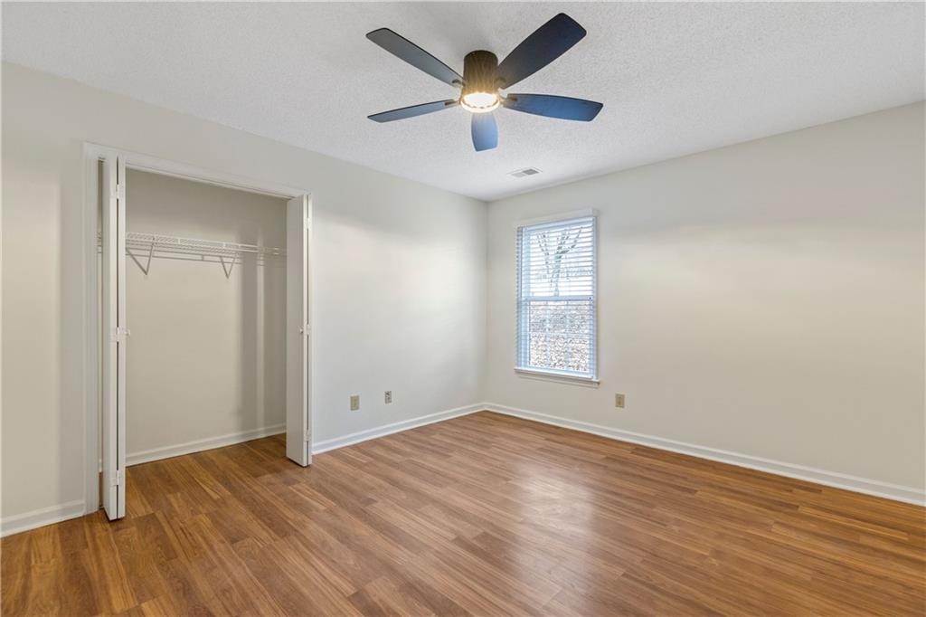 2095 Uniwattee Trail Southeast Dacula, GA 30019 - Photo 11 of 20 an empty room with wooden floor and windows