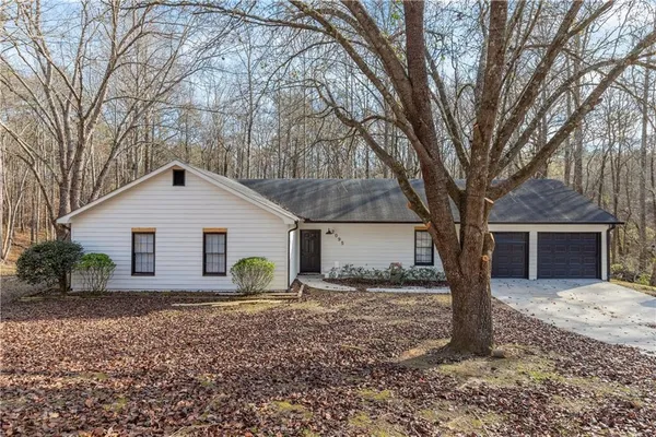 a view of a house with a yard and large tree