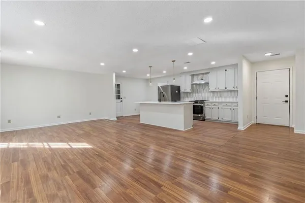 a view of a kitchen with a sink and dishwasher a refrigerator with wooden floor