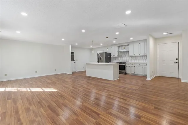 a view of a kitchen with a sink and dishwasher a refrigerator with wooden floor