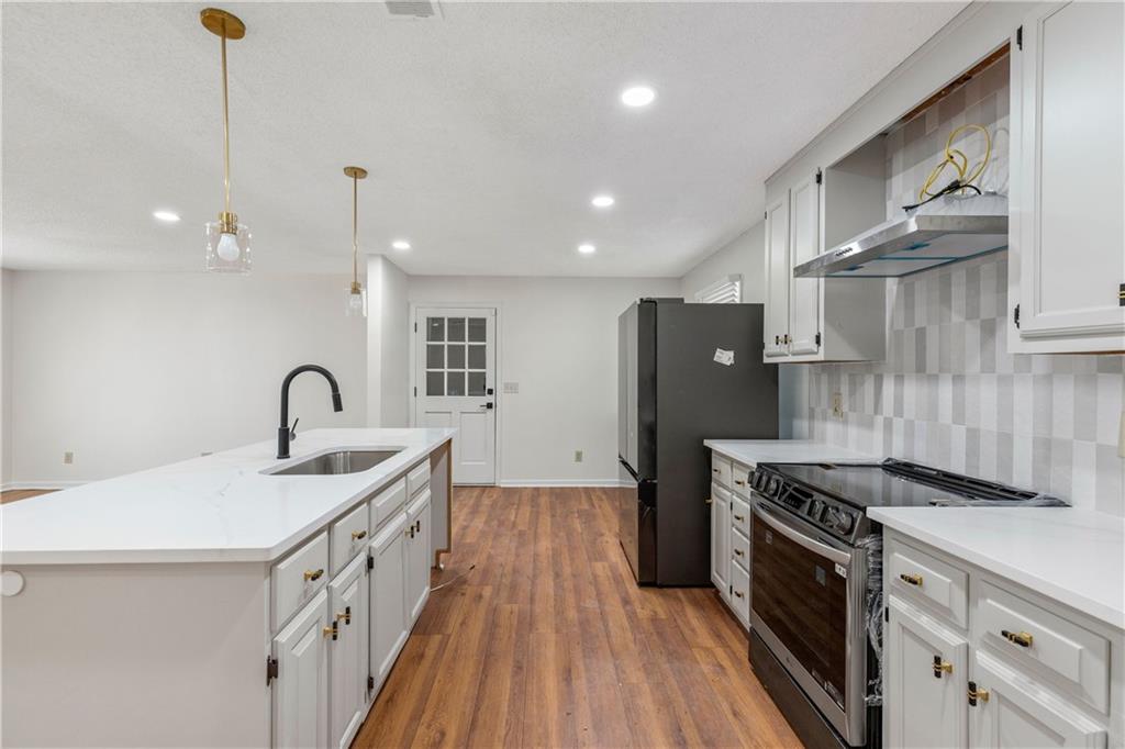 2095 Uniwattee Trail Southeast Dacula, GA 30019 - Photo 7 of 20 a kitchen with stainless steel appliances granite countertop a sink stove and refrigerator