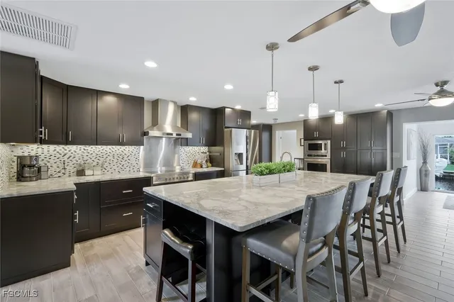 a kitchen with granite countertop a kitchen island a sink stainless steel appliances and cabinets