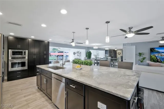 a kitchen with kitchen island a counter top space appliances and cabinets