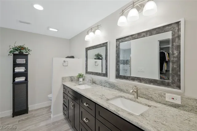 a bathroom with double vanity sinks and a mirror
