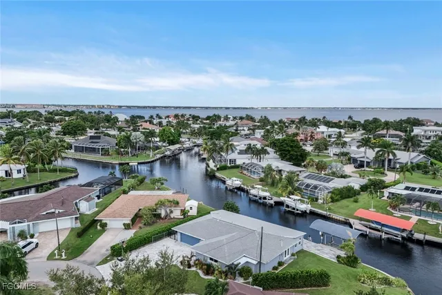 an aerial view of a city with lots of residential buildings and ocean view in back