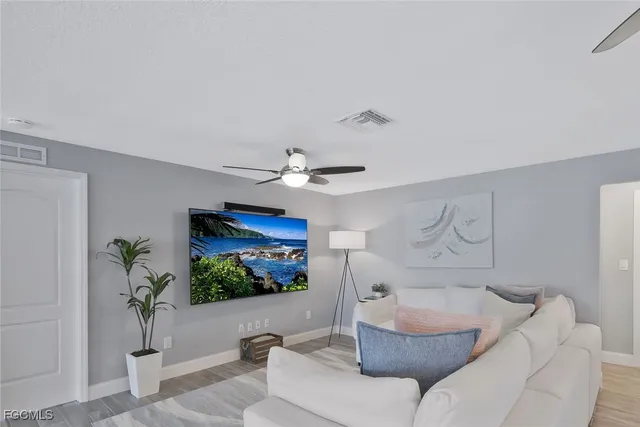 a living room with furniture a window and a flat screen tv