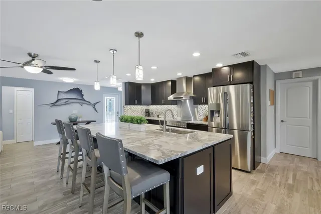 a kitchen with a table a refrigerator and chairs