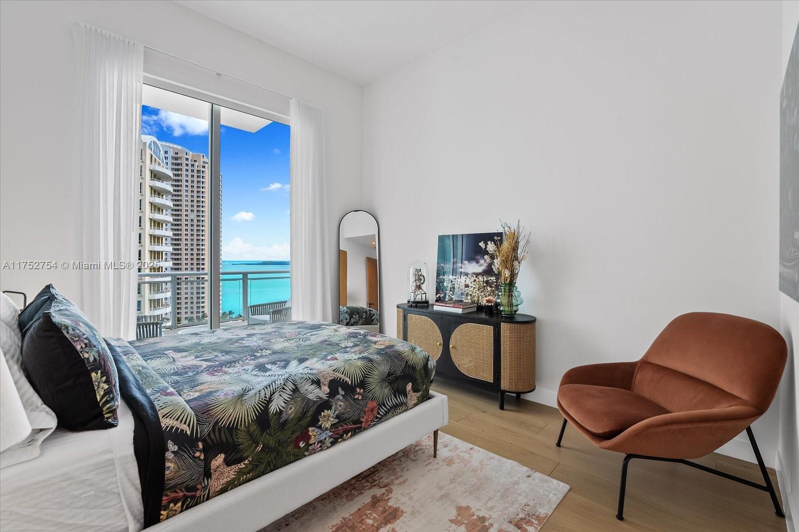 900 Brickell Key Boulevard, Unit 1604 Miami, FL 33131 - Photo 23 of 49 a bedroom with a bed and a chair