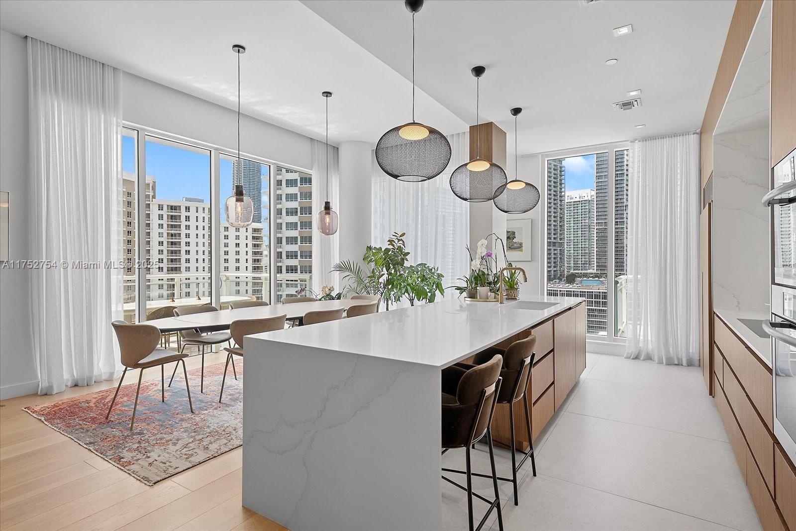 900 Brickell Key Boulevard, Unit 1604 Miami, FL 33131 - Photo 9 of 49 a kitchen with a table and chairs