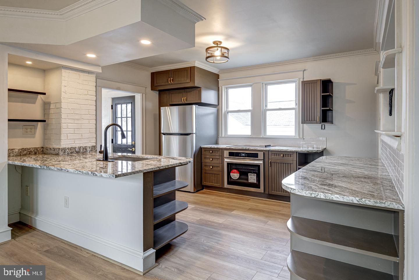 1363 Maple Avenue Croydon, PA 19021 - Photo 6 of 29 a kitchen with granite countertop a stove top oven a sink dishwasher and a fireplace with wooden floor