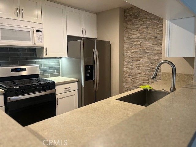 a kitchen with a refrigerator stove and cabinets