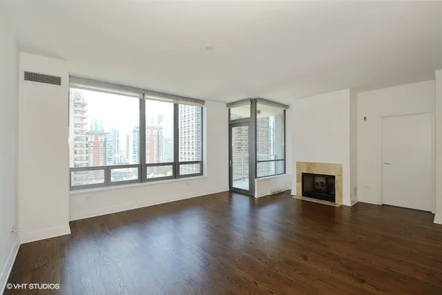 wooden floor fireplace and windows in an empty room