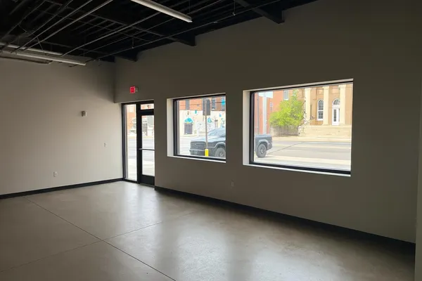 a view of a room with wooden floor and windows