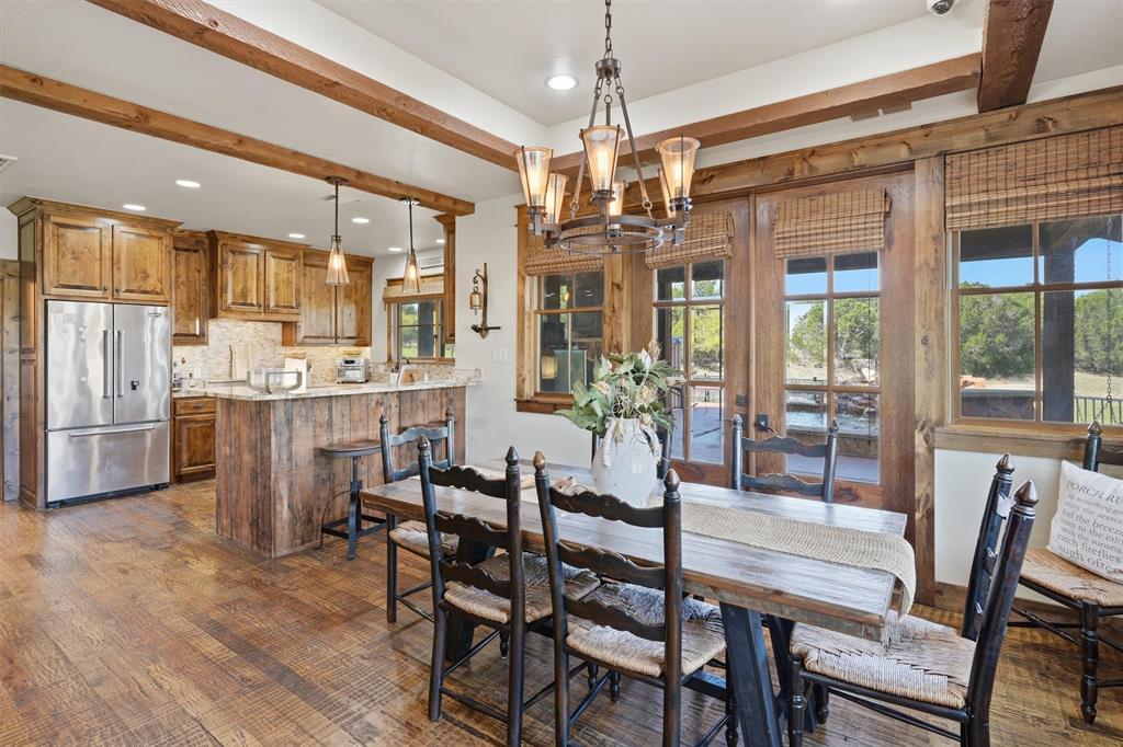 1080 Cascade Lane Graford, TX 76449 - Photo 13 of 39 a dining room with furniture a chandelier and wooden floor