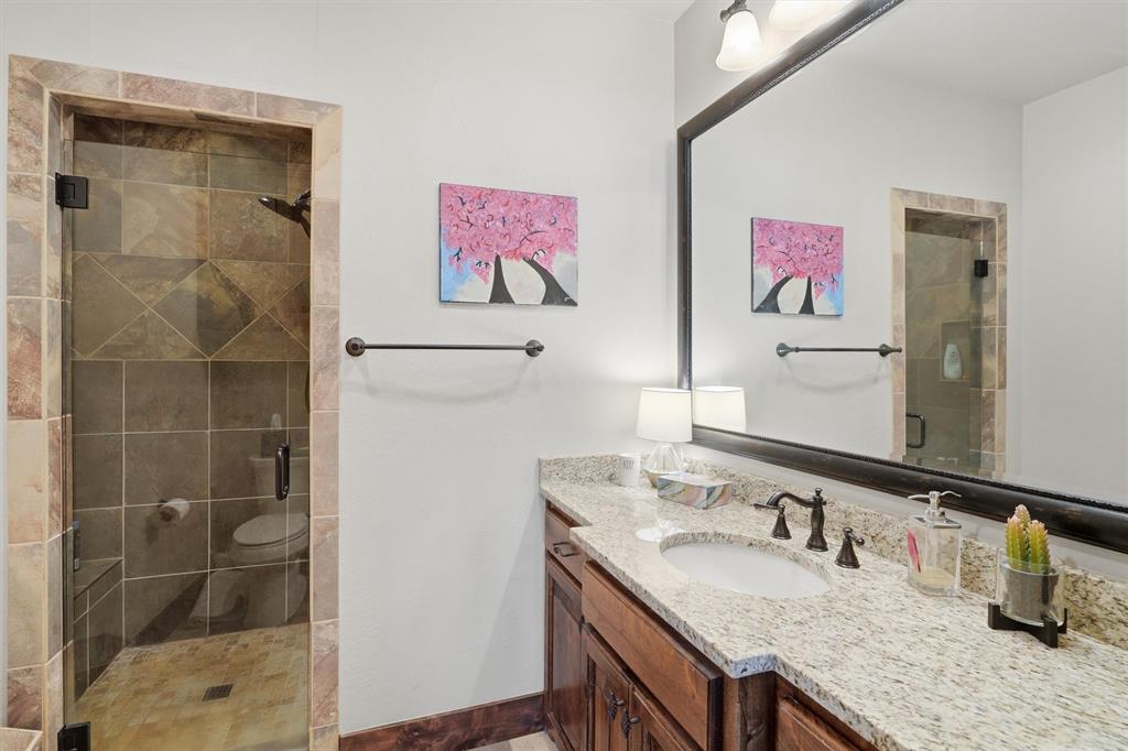 1080 Cascade Lane Graford, TX 76449 - Photo 26 of 39 a bathroom with a granite countertop sink a mirror and a shower