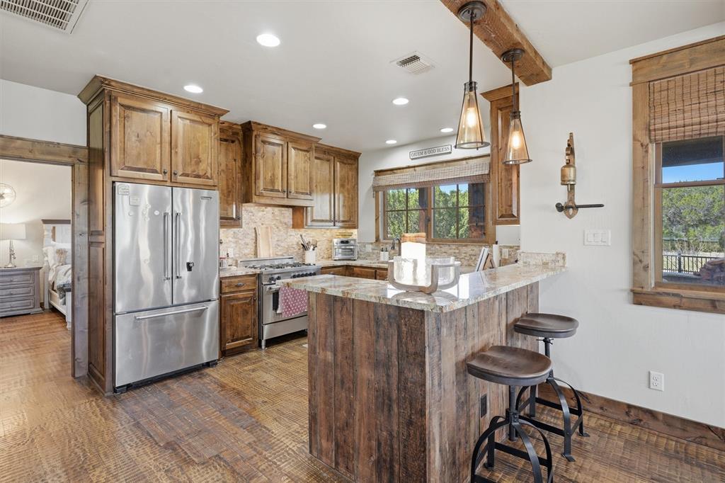 1080 Cascade Lane Graford, TX 76449 - Photo 8 of 39 a kitchen with stainless steel appliances granite countertop a refrigerator a sink dishwasher a stove and a dining table with wooden floor