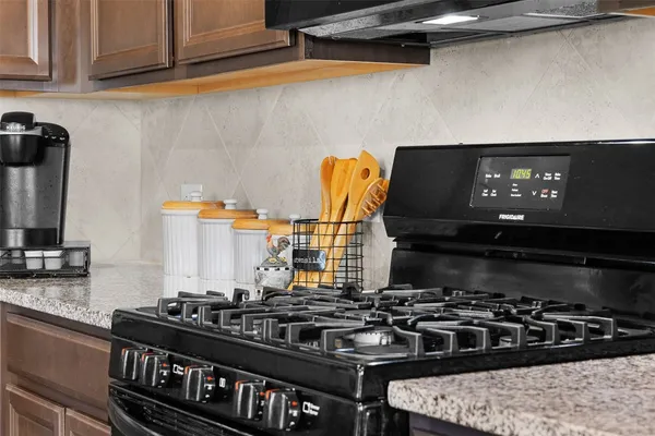 a kitchen with granite countertop stainless steel appliances and wooden cabinets
