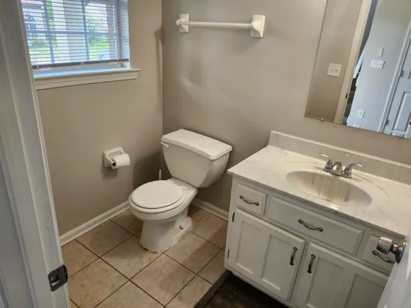 a bathroom with a toilet sink vanity and mirror