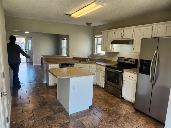 a kitchen with stainless steel appliances granite countertop a stove a refrigerator a sink a microwave and island