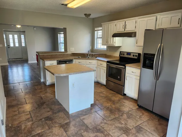 a kitchen with stainless steel appliances granite countertop a stove a sink and a refrigerator