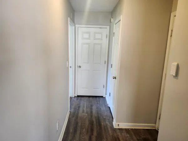 a view of a hallway with wooden floor